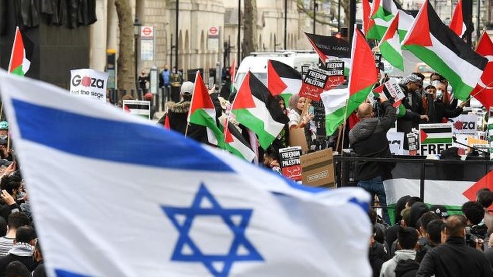 Una bandera israelí con banderas palestinas en el fondo, durante una manifestación en Londres, 11 mayo 2021