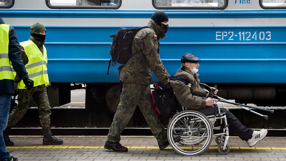 Un soldado polaco ayuda a un refugiado que acaba de llegar en un tren a Przemysl.