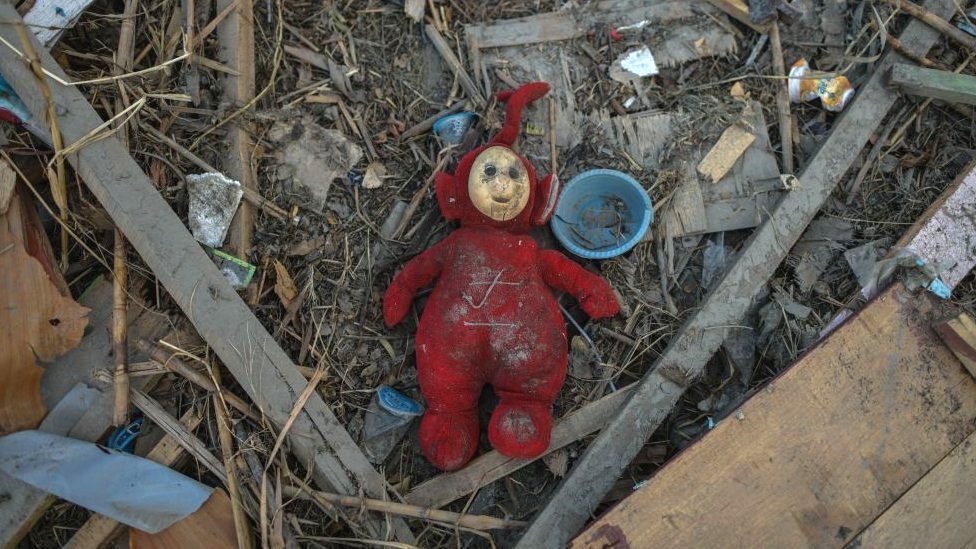 Childrens toys in the rubble of houses
