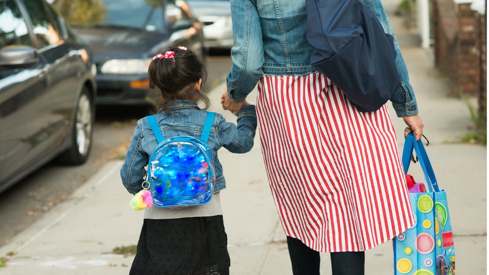 Мать и дочь идут в школу Сток фото