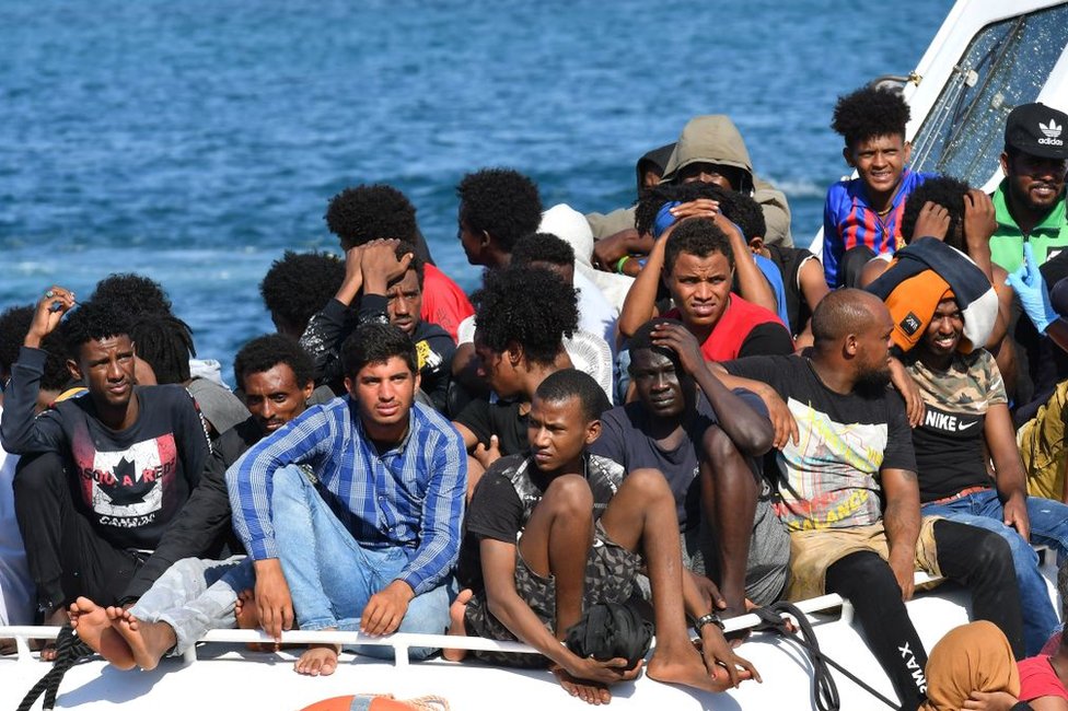 Migrantes de Túnez y Libia llegan a bordo de un barco de la Guardia Costiera italiana (Guardia Costera) en la isla Pelagia italiana de Lampedusa el 1 de agosto de 2020.