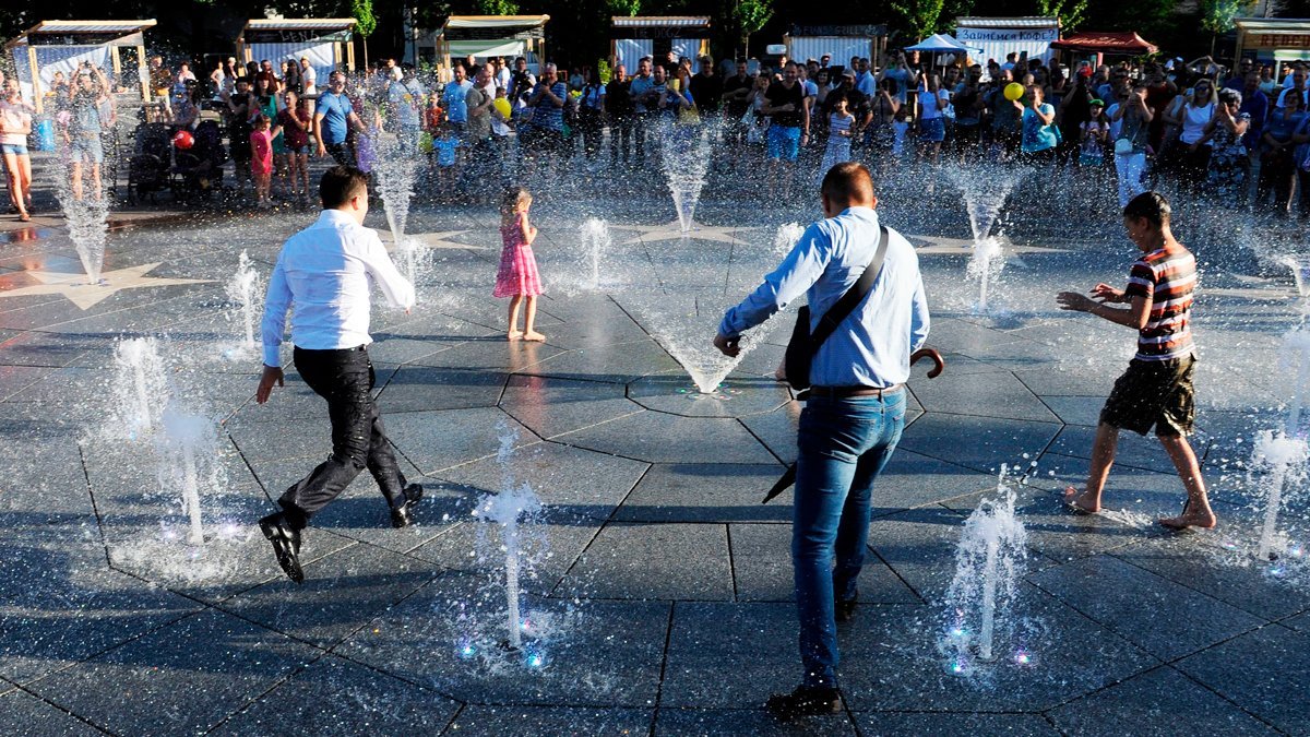Predsednik Vladimir Zelenski (levo) i deca igraju se u fontani tokom prve zvanične posete Marijupolju 15. juna 2019. godine