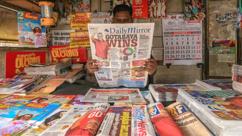 Мужчина из Шри-Ланки читает газету Шри-Ланки, в заголовке которой говорится о победе новоизбранного президента Готабая Раджапакса