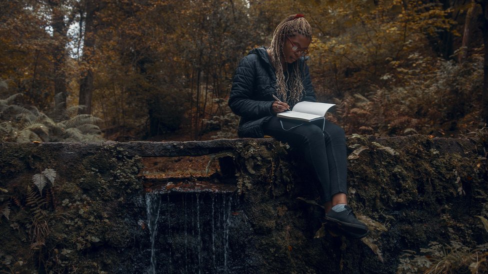 Женщина пишет в лесу