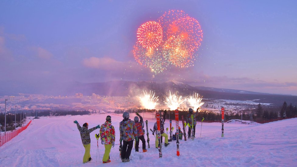 people on a skiing hill overlooking fireworks during a ribbon-cutting ceremony to open a Township of Samjiyon County