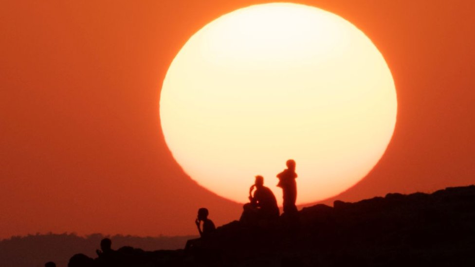 Ethiopian refugees who fled the Ethiopia's Tigray conflict watch the sunset on a hill at the Um Raquba refugee camp in Sudan's eastern Gedaref state - 12 December 2020
