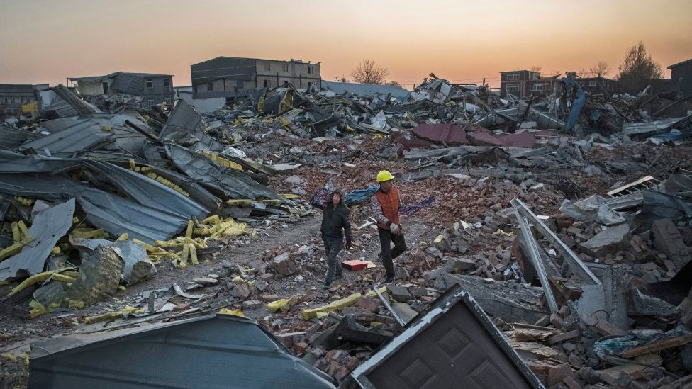 Workers salvage material from demolished buildings in Beijing (6 Dec 2017)