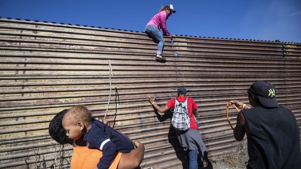 Centenares de migrantes, incluyendo mujeres y niños, intentaron cruzar hacia EE.UU. saltando una valla en la frontera con México.