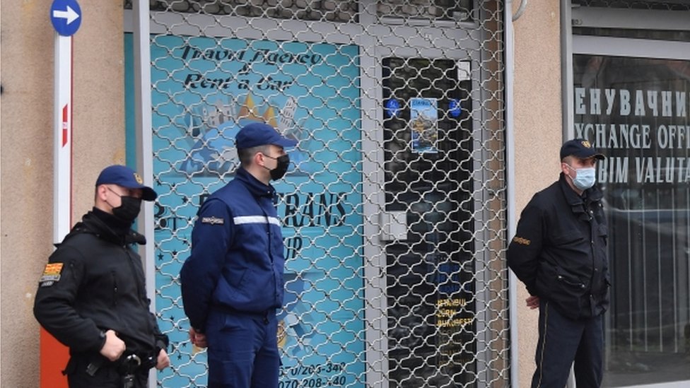 Police officers stand guard in front of the offices of "Besa Trans" travel agency in Skopje, Republic of North Macedonia, 23 November 2021