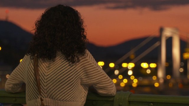 Hungarian woman looking over Budapest at sunset