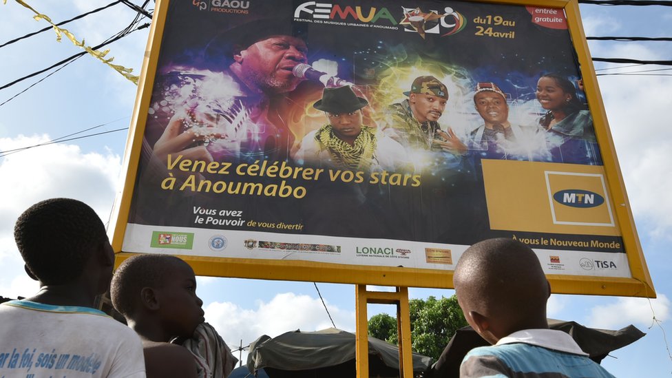 Дети смотрят на плакат, объявляющий о музыкальном фестивале Femua