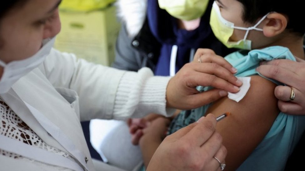 Criança sendo vacinada contra a covid-19 na França