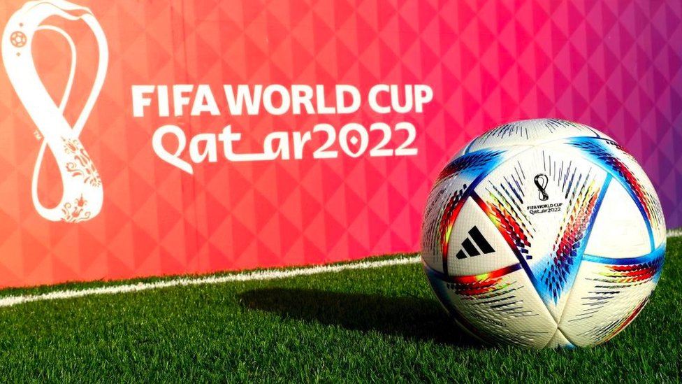 A football in front of a Qatar 2022 logo