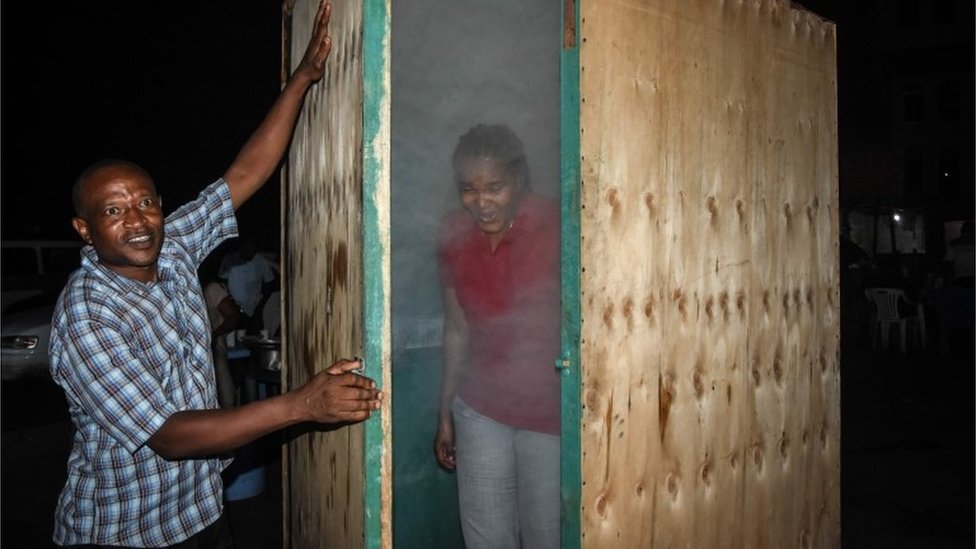 Женщина выходит из кабины паровой ингаляции, установленной танзанийским травником Мсафири Мджема в Дар-эс-Саламе, Танзания, 22 мая 2020 года после того, как использовала лечение в качестве превентивной меры против коронавируса COVID-19