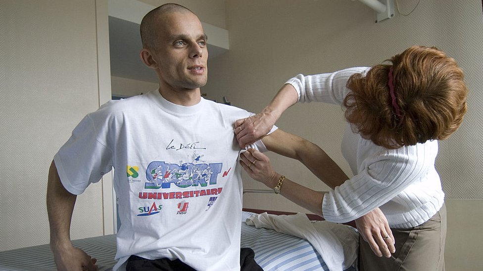 Paciente joven de cáncer es asistido por su madre antes de una sesión de quimioterapia.