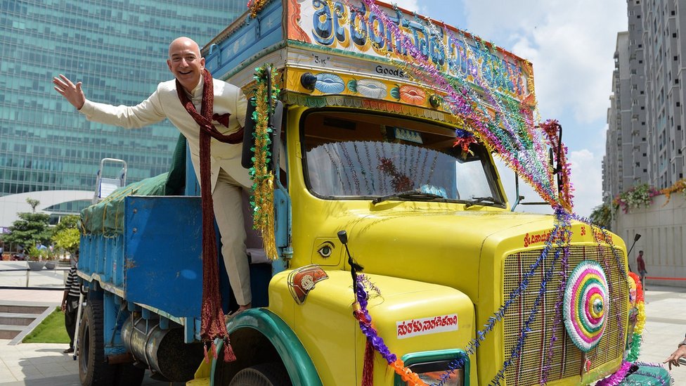 Основатель и генеральный директор Amazon.com Джефф Безос из США позирует в грузовике после вручения чека на два миллиарда долларов вице-президенту Индии и региональному менеджеру Amazon.in Амиту Агарвалу (не показано) в Бангалоре 28 сентября 2014 г.