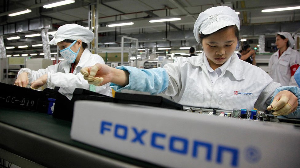 Employees work on the assembly line at Hon Hai Group's Foxconn plant in Shenzhen, China, on Wednesday, May 26, 2010.