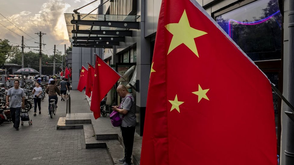 Китайские флаги возле ряда магазинов