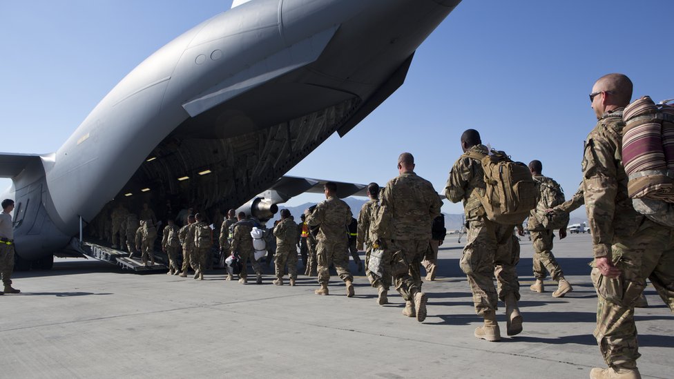 Soldados de EE.UU. caminan hacia el avión de carga C-17 para salir de la base aérea de Bagram el 11 de mayo de 2013