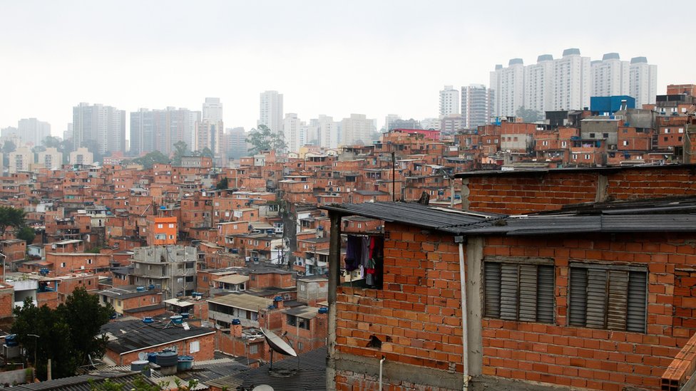 Casas em Paraisópolis, com prédios ao fundo