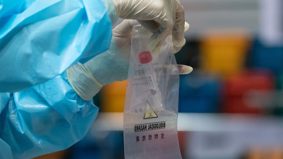 香港某新冠病毒全民檢測採樣中心內一名技術人員把樣本封裝送檢（1/9/2020）