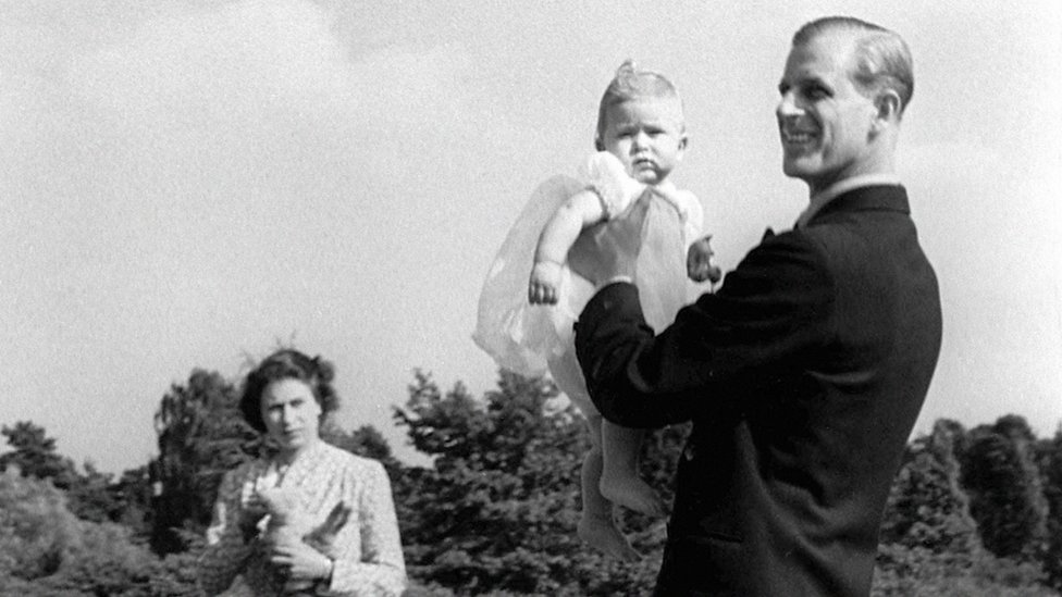 Prince Charles, later The Prince of Wales, is lifted up by his father The Duke of Edinburgh, in the grounds of Windlesham Moor, the country home in Surrey of Princess Elizabeth and the Duke. 18 July 1949