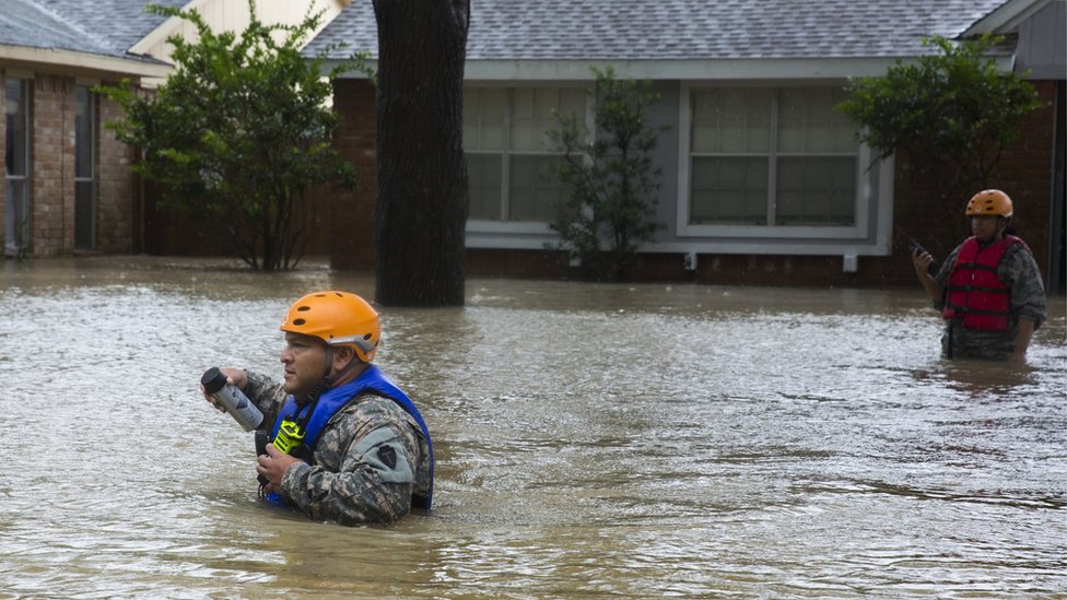 Un rescatista camina por Bear Creek, en el oeste de Houston, buscando a personas que puedan estar varadas en sus casas. Un rescatista camina por la parte oeste de Houston buscando a personas que puedan estar varadas en sus casas.
