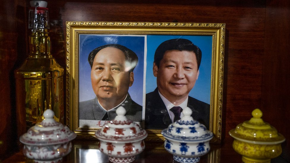 Portarretrato con la foto de Mao y de Xi.
