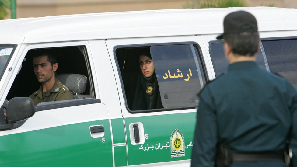 Женщина-полицейский выглядит из фургона иранской полиции по вопросам нравственности в Тегеране в июле 2007 года