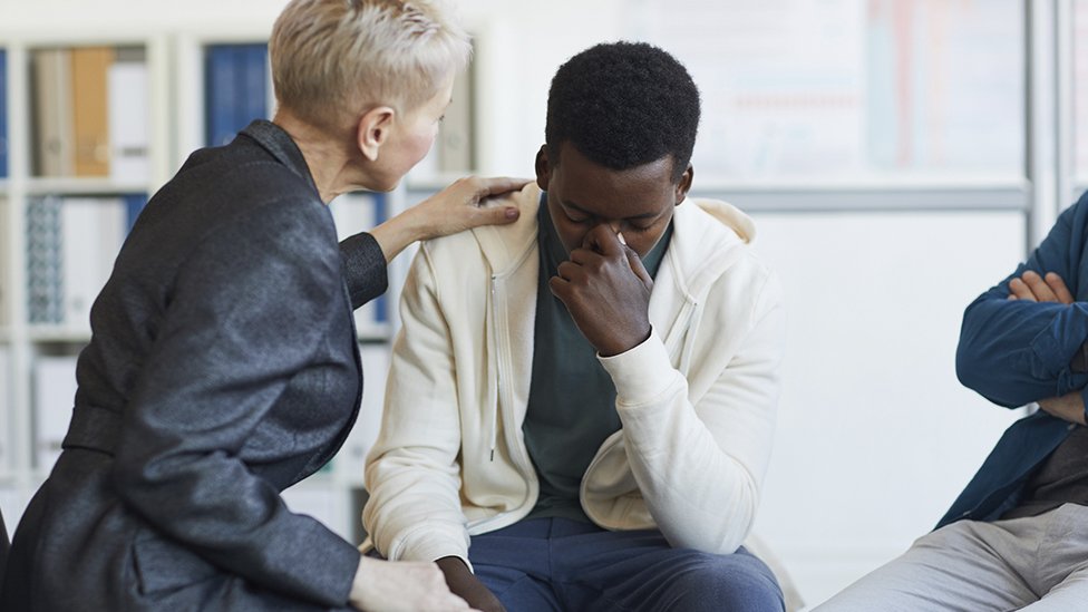 A teenager being comforted