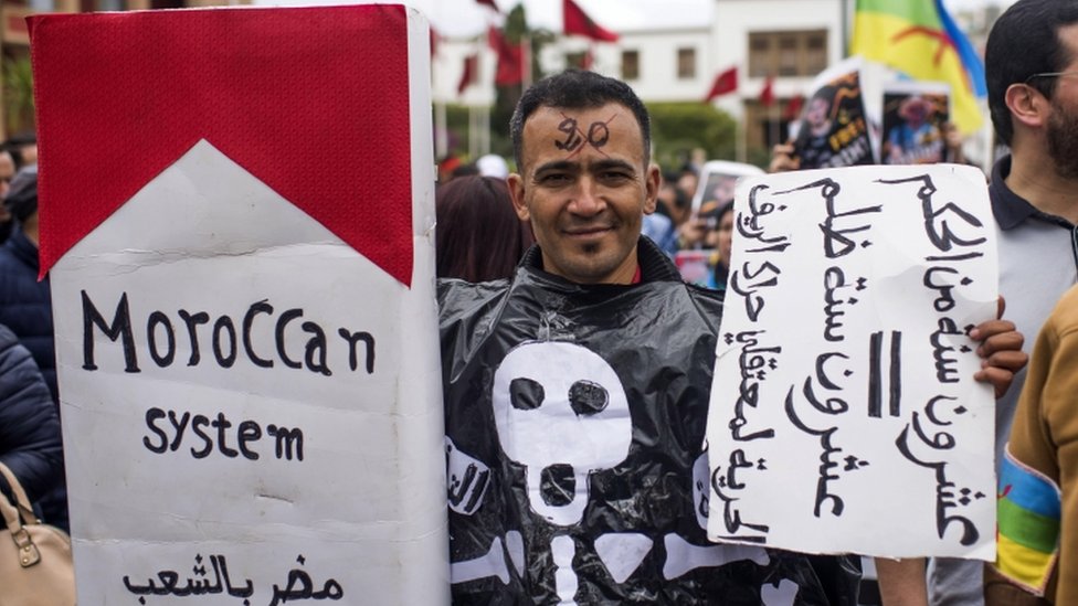 Марокканский демонстрант держит плакат с надписью на арабском языке «20 лет заключения = 20 лет несправедливости»