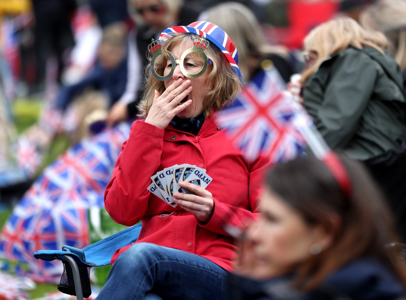 A spectator yawns as she waits to watch the procession on a screen at Hyde Park
