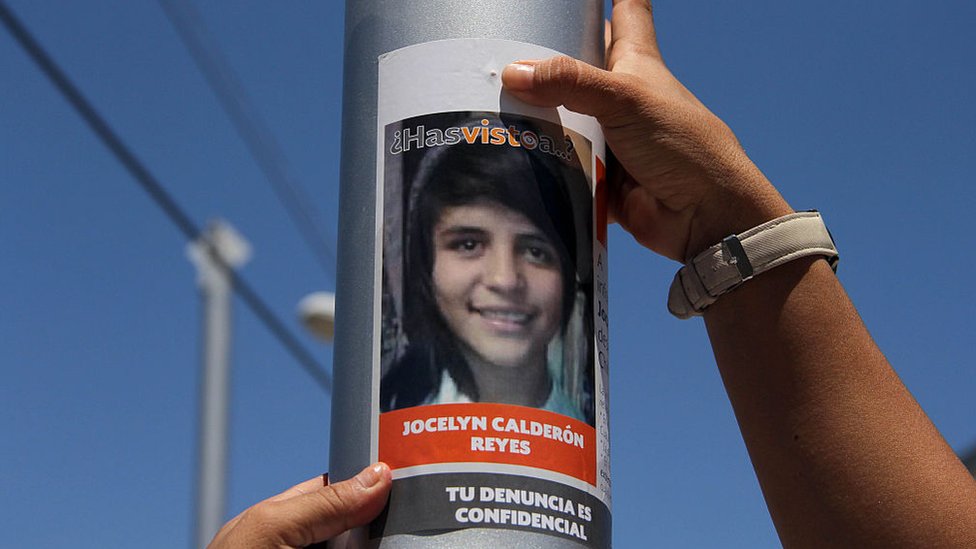 En México, siete mujeres son asesinadas cada día, según las estadísticas. Una manos de mujer colocan un cartel en un poste pidiendo información sobre una mujer desaparecida en Ciudad Juárez
