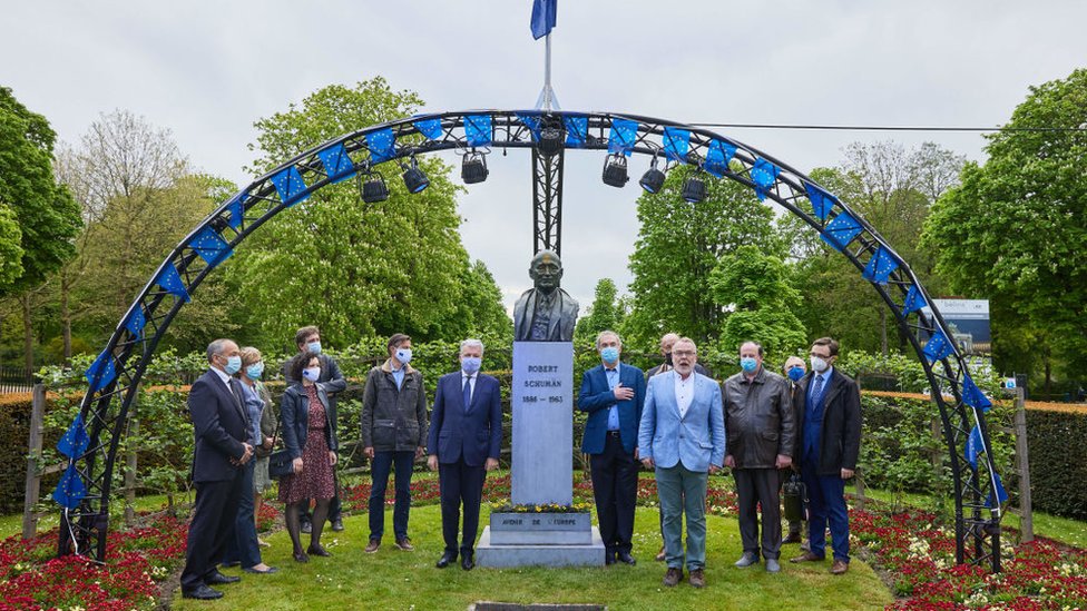 Funcionarios de la UE celebrando el Día de Europa en un busto de Robert Schuman