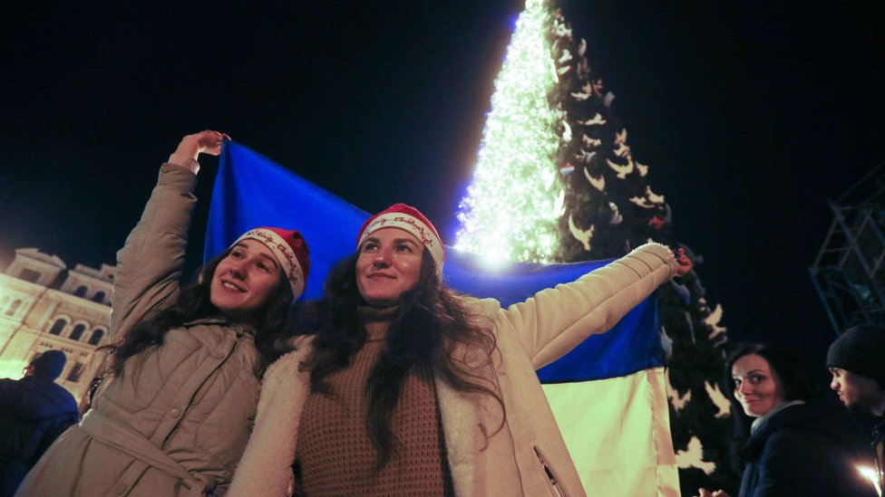 Dos mujeres junto a un árbol de Navidad en el centro de Kyiv.