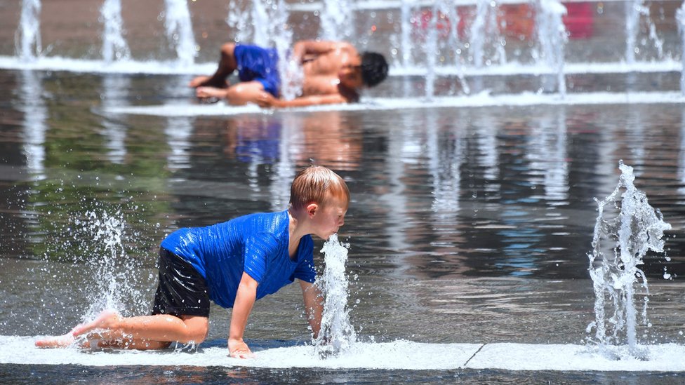 Niño refrescándose en Grand Park, Los Ángeles, California, en julio.