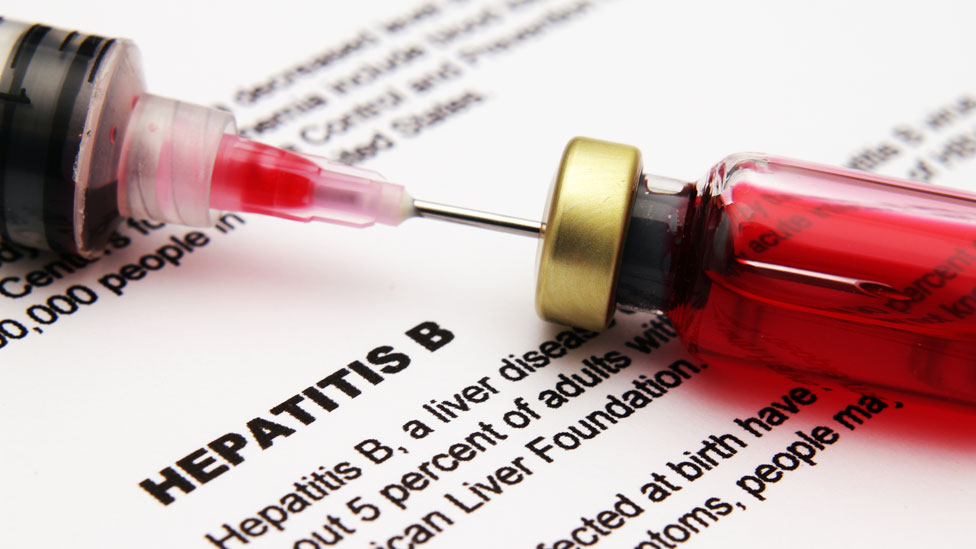 Una aguja en una muestra de sangre sobre un documento que dice "hepatitis B"