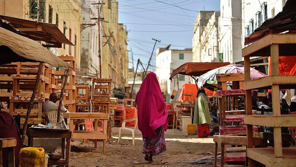 Женщина идет по улицам Могадишо