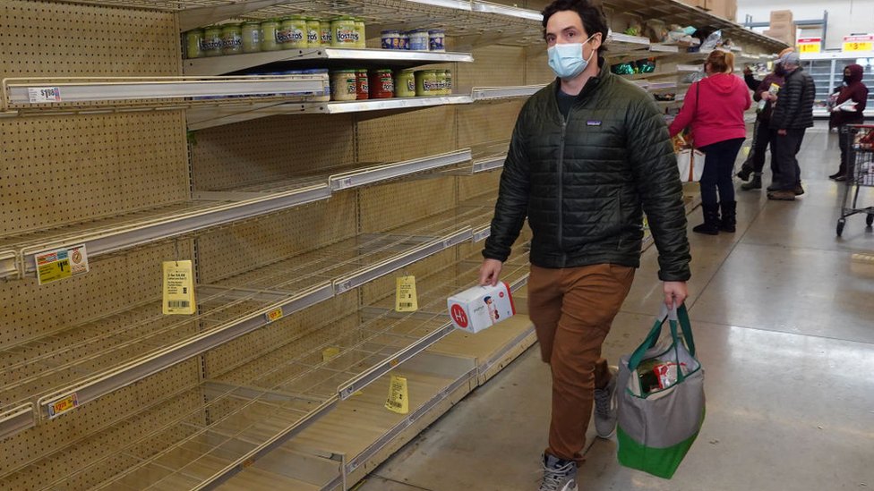 Hombre camina frente a una góndola vacía en un supermercado de Texas.