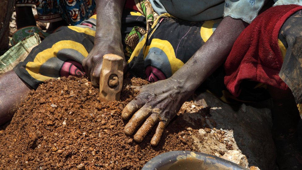 Женщина разбивает камни, содержащие касситеритовую руду, на шахте в районе Сибира, Демократическая Республика Конго, в апреле 2009 г.
