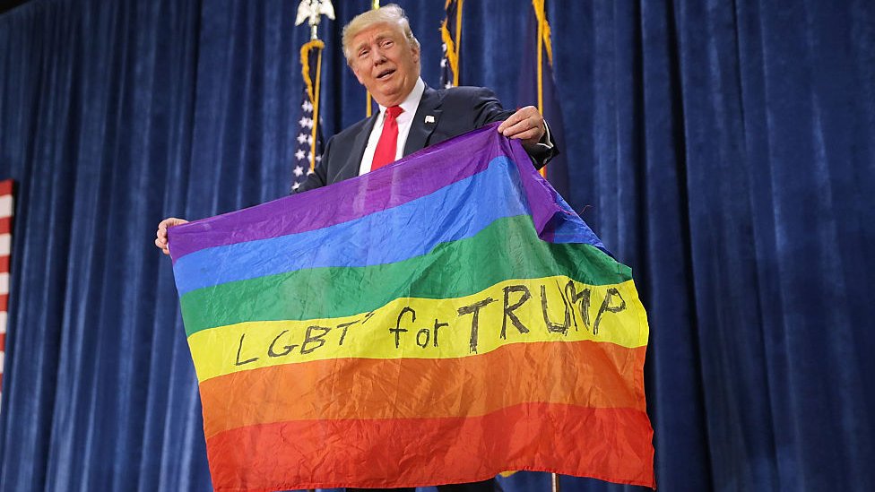 Trump em 2016 segurando a bandeira do arco-íris