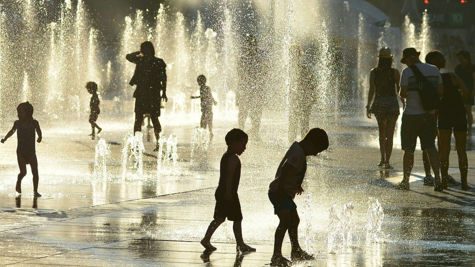 Niños jugando en una fuente de agua en Montreal, Canadá.