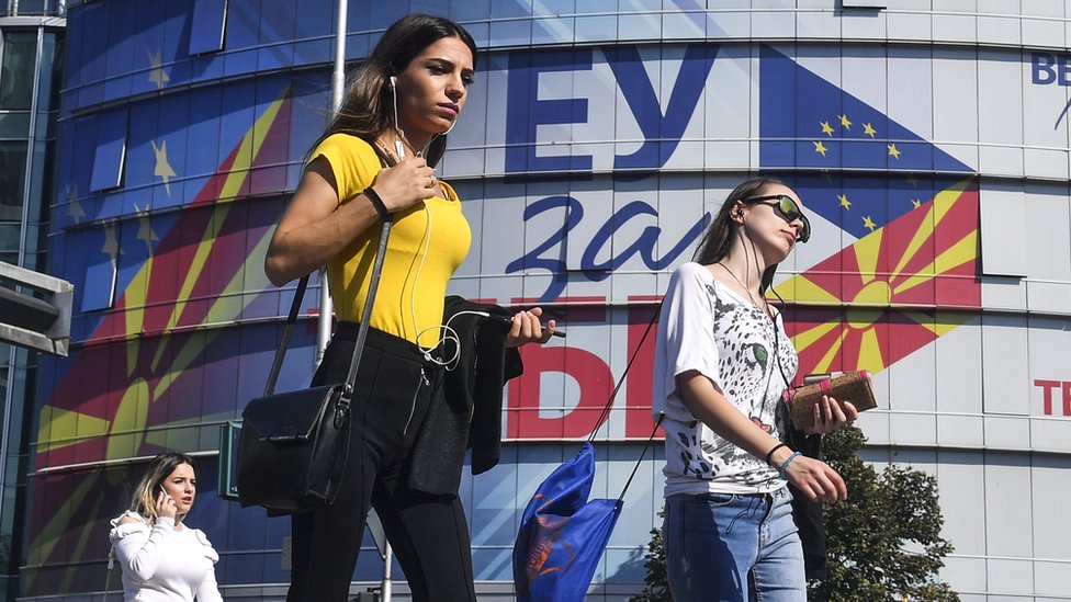 Люди ходят перед офисами Европейского Союза с логотипами «ЕС для вас» в Скопье, Северная Македония (18 октября 2019 г.)
