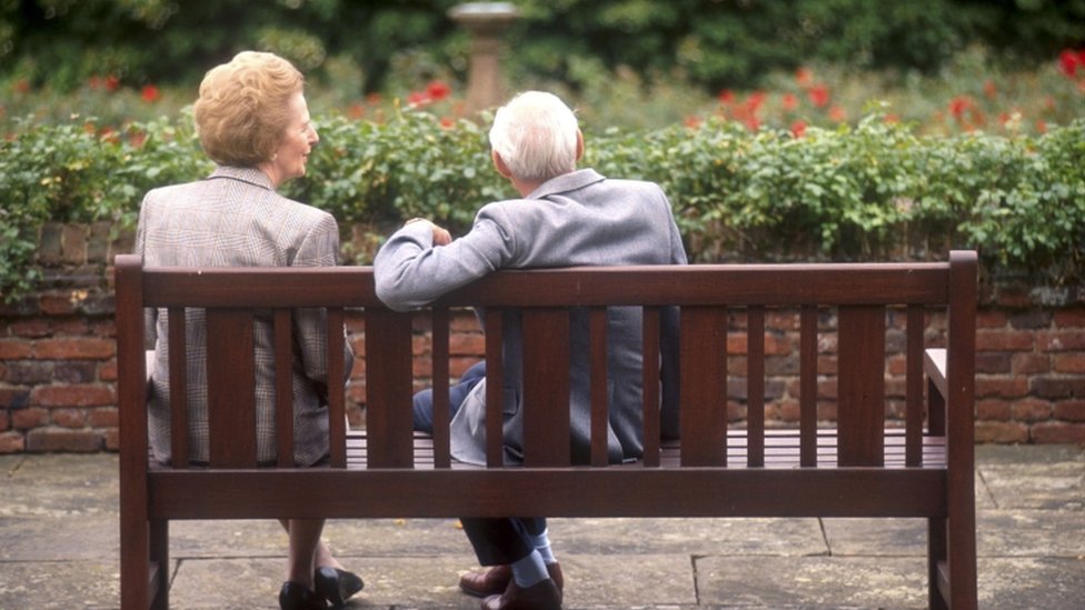 Маргарет Тэтчер сидит на скамейке со своим мужем Денисом в шашках