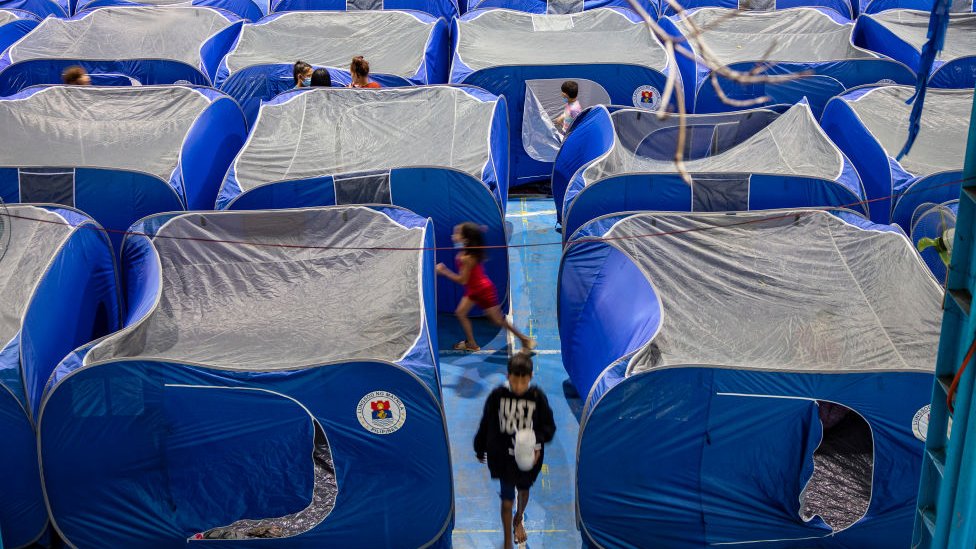 Filipinos take shelter in tents inside a school gymnasium converted into an evacuation centre before Typhoon Goni hits on November 1, 2020 in Manila, Philippines