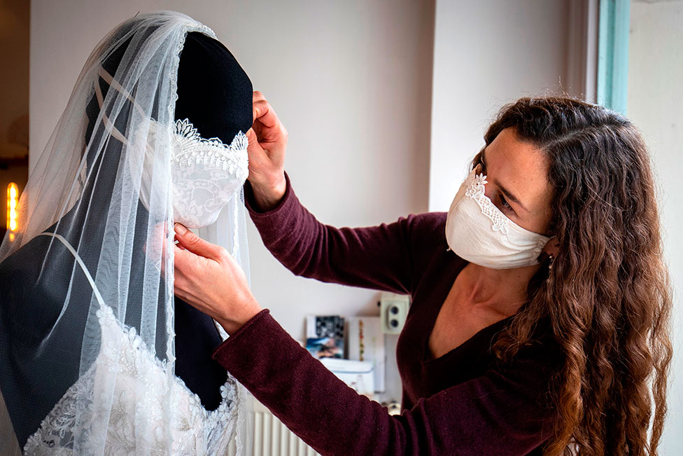 Gelinlik ve gecelik tasarımcısı Friederike Jorzig, Berlin'deki atölyesinde maskeli bir gelinlik tasarlıyor. Almanya'da düğünlerin de içinde olduğu kitlesel etkinlikler iptal edildi.