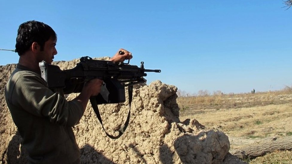 Солдат Афганской национальной армии (АНА) наблюдает за продолжающимся сражением с боевиками Талибана в районе Над Али провинции Гильменд (22 декабря 2015 г.)