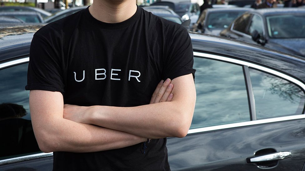 мужчина в футболке Uber со скрещенными руками