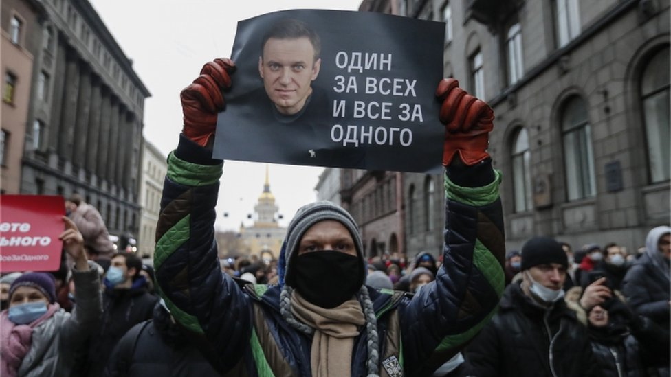 A protester holds a poster that reads "One for all and all for one", during an unauthorized protest in support of Russian opposition leader and blogger Alexei Navalny