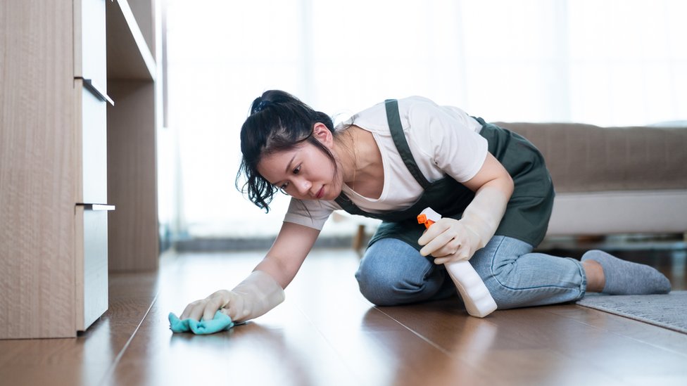 Una mujer limpia un piso